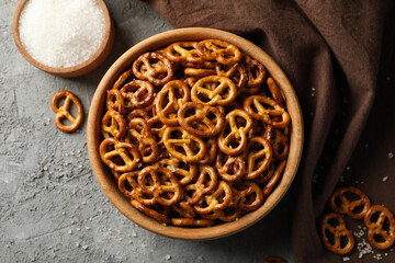 Napkin and bowl with cracker pretzels on gray background