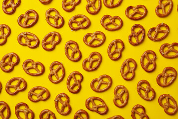 Tasty cracker pretzels on yellow background, top view