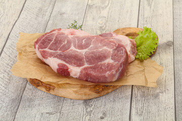 Raw pork steak over wooden board