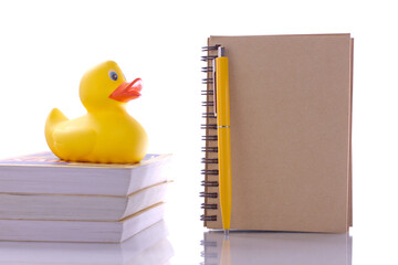 spiral craft notebook for business concept with duck and books on white background