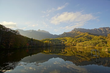 A pond that reflects trees and mountains like a mirror. At dusk. Beautiful scenery of Japan.
