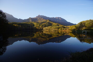 A pond that reflects trees and mountains like a mirror. At dusk. Beautiful scenery of Japan.