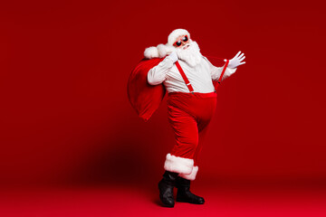 Fototapeta na wymiar Full length body size view of his he attractive childish cheerful cheery funny fat Santa carrying big large sack having fun dancing isolated bright vivid shine vibrant red color background