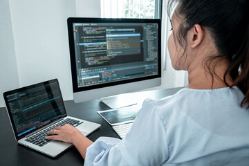 Obraz na płótnie Canvas Female Developer programmer working on coding program software computer, Writing website and development database technology in office
