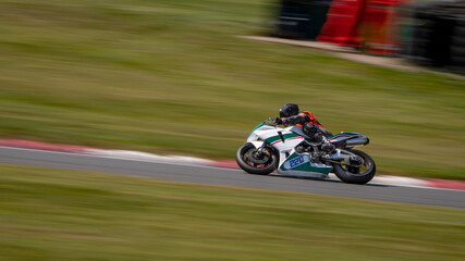 A panning shot of a racing bike cornering on a track.