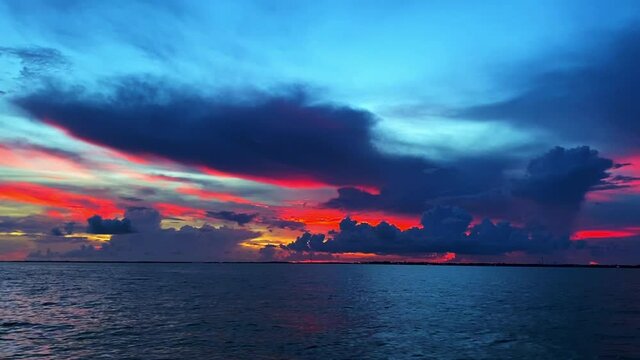 Clip over the ocean with cloudline in the horizon revealing beautiful colors during sunset in Florida Keys, USA