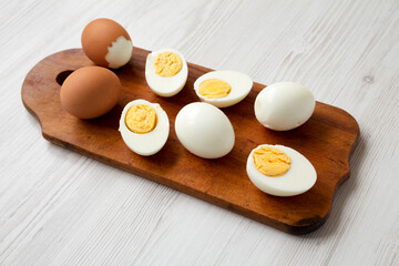 Hard Boiled Eggs on a rustic wooden board, side view.
