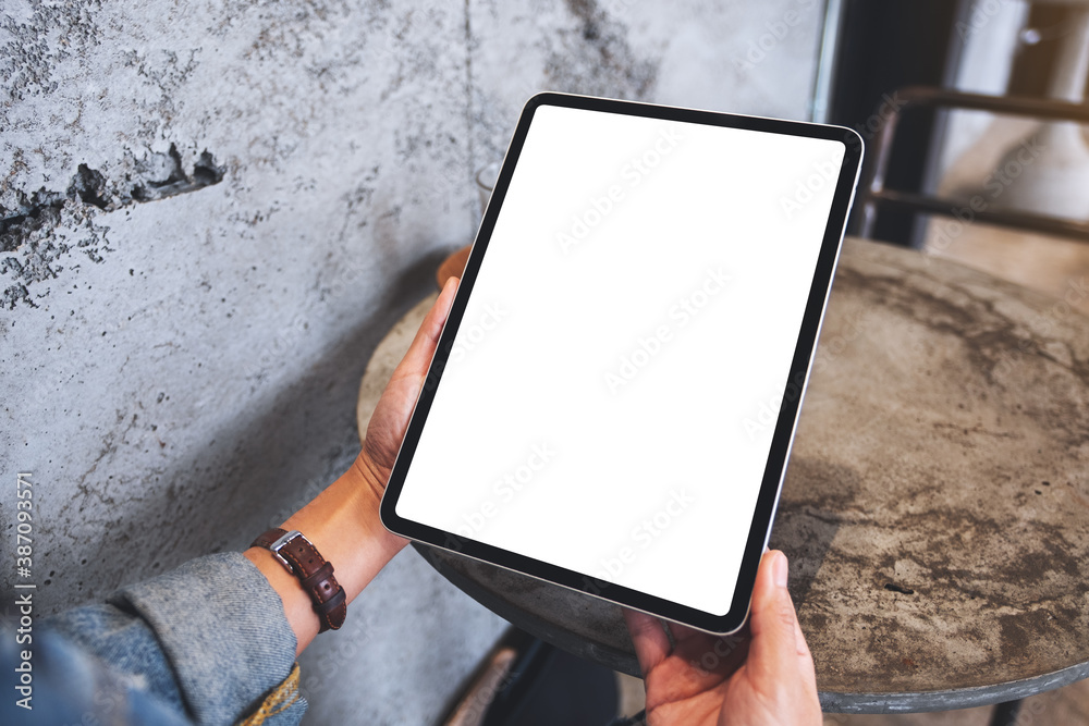 Wall mural mockup image of a woman holding digital tablet with blank white desktop screen