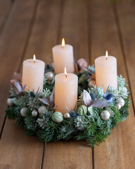 Advent wreath with four burning candles on table