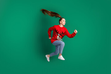 Full body profile photo of crazy pretty lady jump high rush store mall shopper x-mas season buy presents consumerism wear red ugly sweater jeans shoes isolated green color background