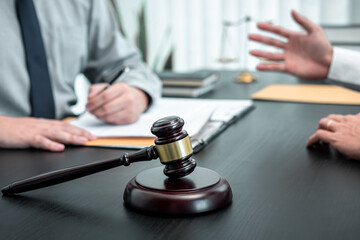 Male lawyer discussing negotiation legal case with client meeting with document contract in office,...