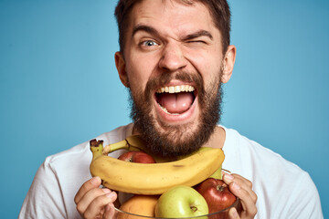 dark background handsome man with a beard holding fresh fruit and lifestyle transparent cup