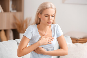 Fototapeta premium Young woman checking her breast at home. Cancer awareness concept