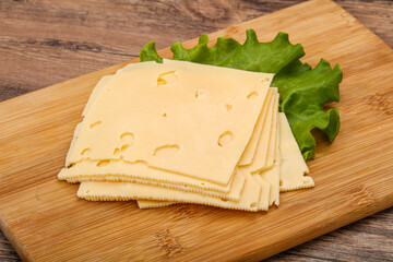 Sliced yellow cheese over board