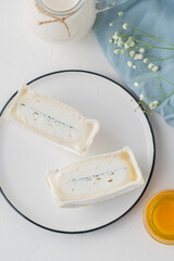 traditional cheese with white and blue mold in the section. Large pieces of sliced cheese on a light table