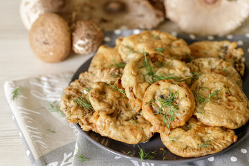 Deep fried caps of wild edible mushroom umbrella on plate