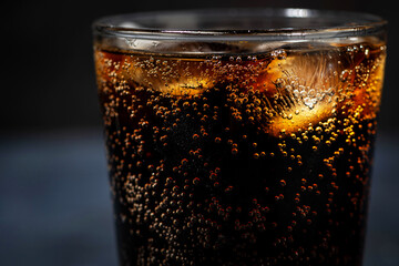 glass of coca cola with ice on a dark background, closeup