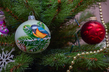 Holiday decorations (bowls, beads, snowflakes) hang on the branches of a Christmas tree