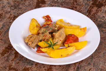 Baked pork meat with potao and tomato