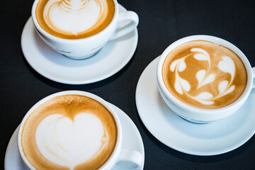three cups of hot cappucino coffees