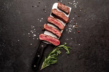 Foto op Canvas Different degrees of roasting steak on a meat knife on a stone background © александр таланцев