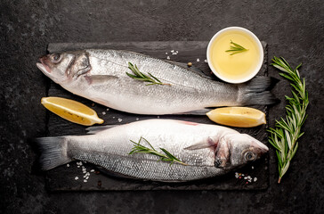 Sea bass fish with spices on a stone background