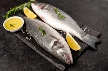 Sea bass fish with spices on a stone background