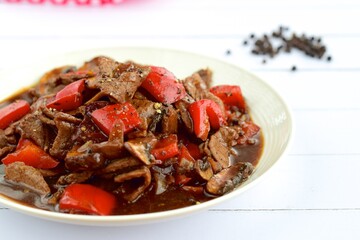 Beef black pepper steak - stir-fried tender beef with red bell peppers and mushrooms.