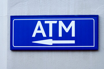 ATM sign on wall pointing with an arrow direction of cash point concept banking and finance