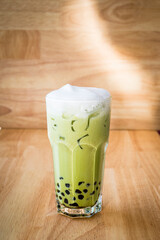 Asian style green bubble tea with milk froth on top