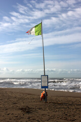 Rotten italian flag on corona empty beach in forte dei marmi, tuscany, italy