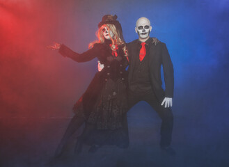 Beautiful happy couple with creepy Halloween make up dead day calavera style dancing