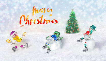 Merry Christmas - funny snowmen carefree on snow in winter new year landscape. Beautiful bokeh circles on snowy background, banner