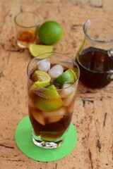 Rum and Coke Cocktail Drink with Lime Wedges and Ice Cubes. Cuba Libre