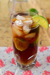 Rum and Coke Cocktail Drink with Lime Wedges and Ice Cubes. Cuba Libre