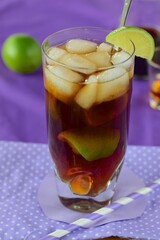 Rum and Coke Cocktail Drink with Lime Wedges and Ice Cubes. Cuba Libre