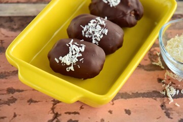 Medjool dates covered dark chocolate garnish with shredded coconut