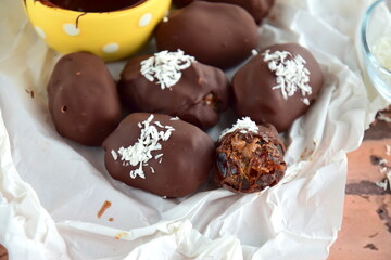 Medjool dates covered dark chocolate filled with almond butter garnish with shredded coconut