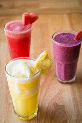 three different Fruit shakes, watermelon,pinapple and mixed berry
