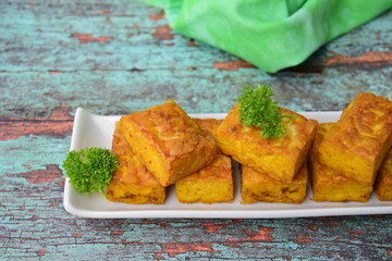 Fried tempeh. Made by a natural culturing and controlled fermentation process that binds soybeans into a cake form. Soybean product originating from Indonesia