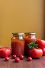 Tomato juice in cans of preserves
Freshly squeezed home juice from fresh vegetables on the table. Ripe  harvest tomatoes refreshment. 
Red vitamin nutrients drink