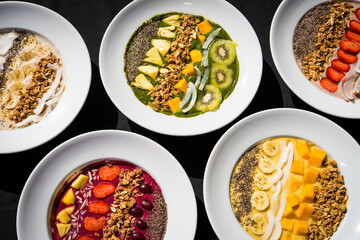 A selection of five different Smoothie bowl with different fruits, yogurt, granola and nut seeds