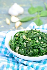Sauteed garlic spinach. Healthy diet vegetarian. Blurred background