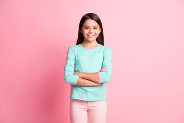 Fototapeta premium Photo of charming sweet lovely small hispanic lady long hairstyle crossed hands self-assured cool toothy shiny smile wear turquoise sweatshirt pants isolated pink color background