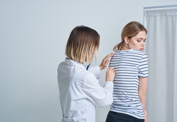 doctor woman in medical gown with stethoscope listens to patient's heart