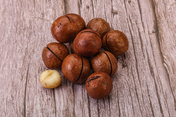 Brown macadamia nut heap over background