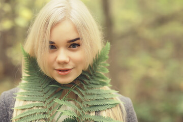 Fototapeta premium eco concept girl portrait fern, young adult model blonde, green leaf on face