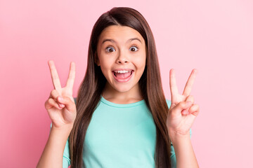Photo of funny shocked cute lovely little hispanic lady long hairdo excited raise two hands show v-sign open mouth wear casual turquoise teal sweatshirt isolated pink color background © deagreez