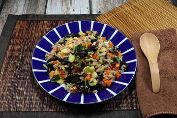 Fried and stirred cooked rice with fresh cutting carrot, sliced baby corn, black jelly fungus and Chinese celery on the plate. Famous traditional vegetarian menu in Asia restaurant. High fiber.