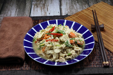 Fried and stirred spicy soft tofu with chilly and Chinese celery on the plate. Famous traditional vegetarian menu in Asia restaurant. High fiber and vitamin food. Low fat and diet concept. 
